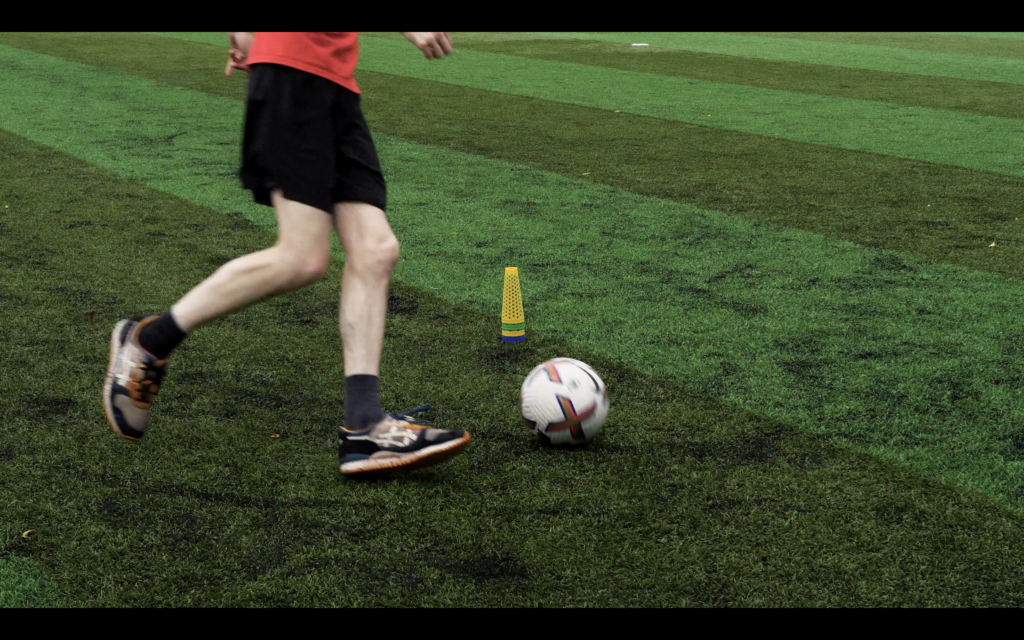 cone in the middle of screen with someone dribbling around it