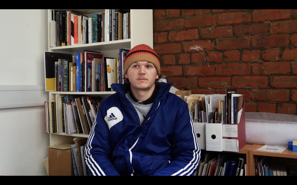 interviewing someone with books in the background
