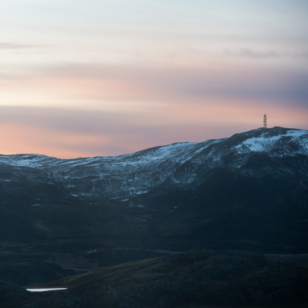 hill with snow and telephone mast